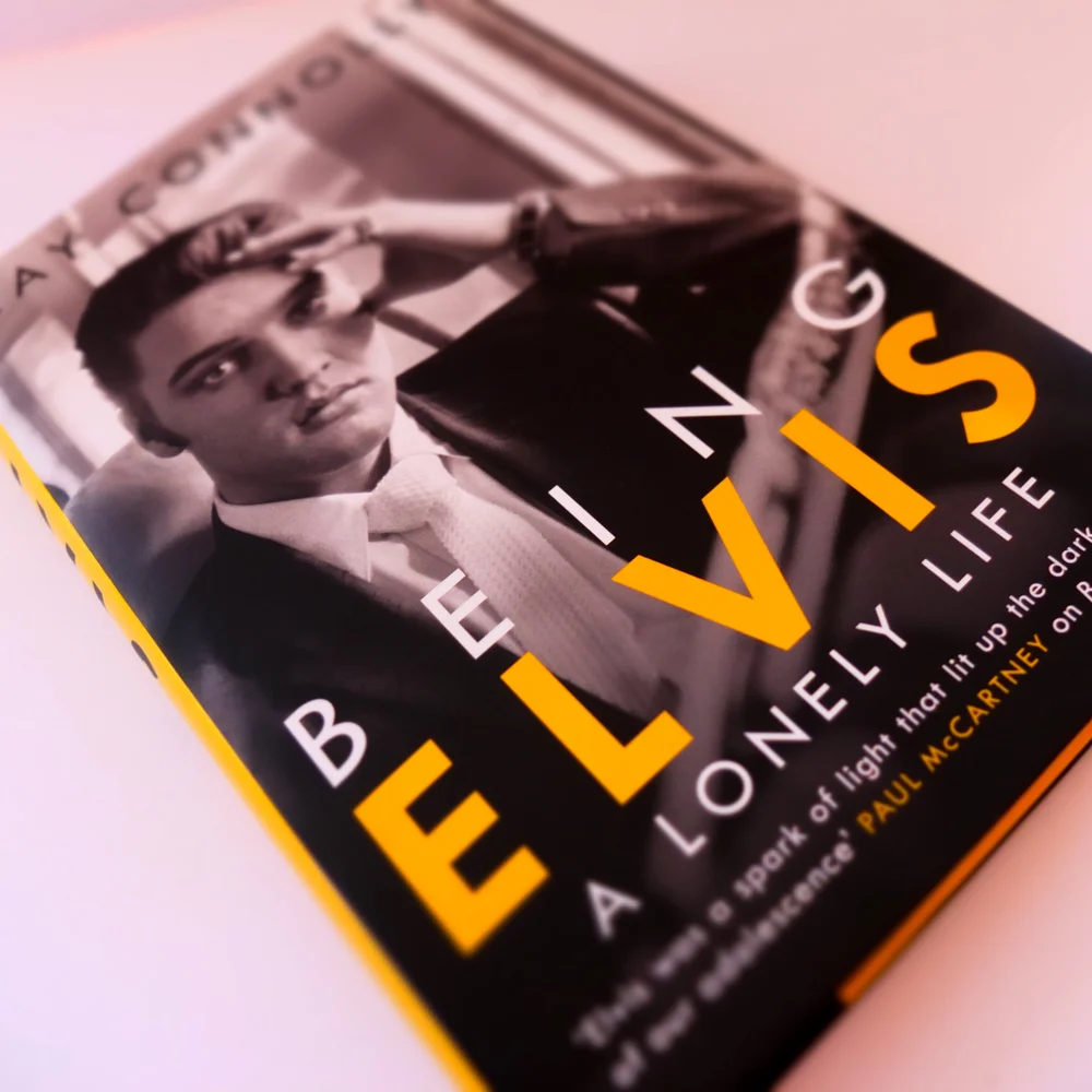 Hardback of Being Elvis: A Lonely Life, black cover with a photograph of a young Elvis and bold yellow type