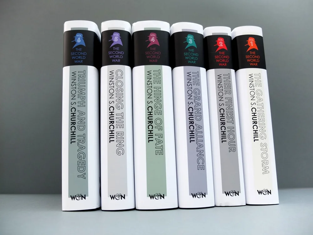 The six volumes shelved together, spines forming a colour-coded set with a small Churchill silhouette on each
